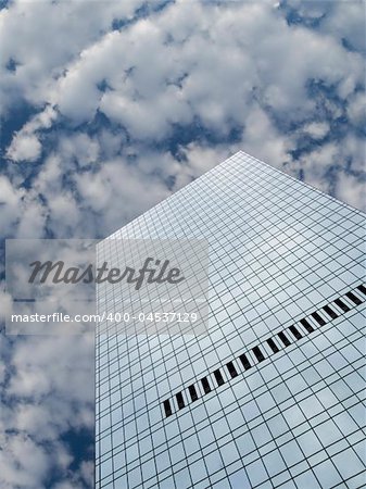 High modern skyscraper on a background of a blue sky and clouds.