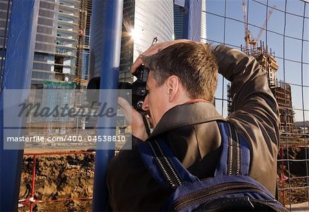 Mature photographer at work photographing construction area