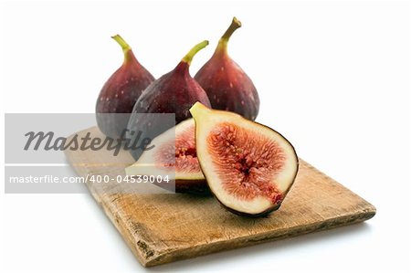 three whole figs and one sliced one isolated on white