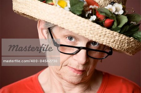 Senior woman in a red shirt and straw hat