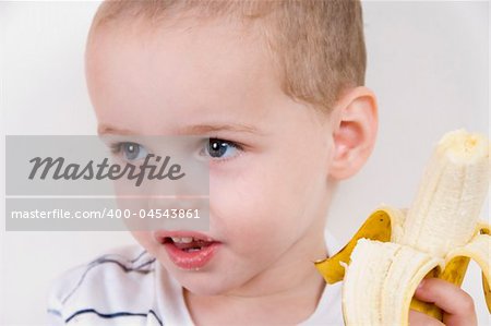 portrait of little boy with peeled banana