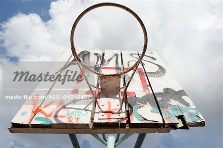 Old basketball hoop with graffity at the blue sky