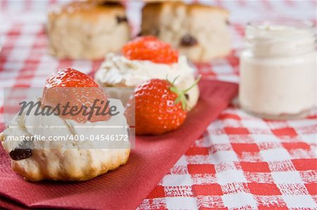 Scones, strawberries and clotted cream on a red napkin