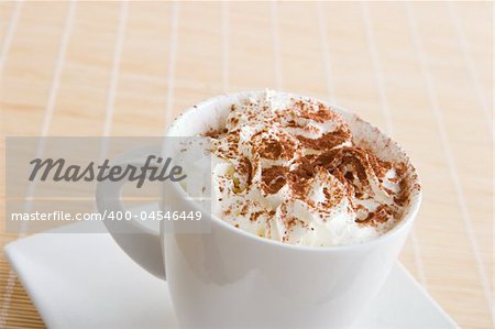 A cup of coffee with  cream and chocolate on top