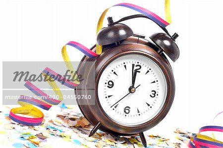 Waiting the New Year with clock, confetti and ribbons. Shallow depth of field