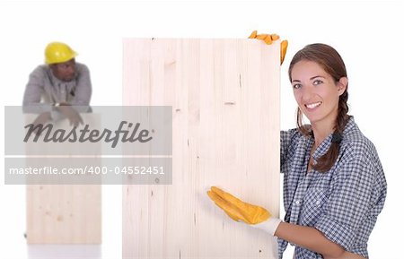 Young african american carpenter and woman carpenter holding wooden plank