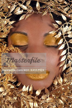 African American Woman With Eyes Closed Wrapped in Metallic Leaves