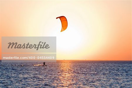 Silhouette of a kitesurfer on a gulf on a sunset