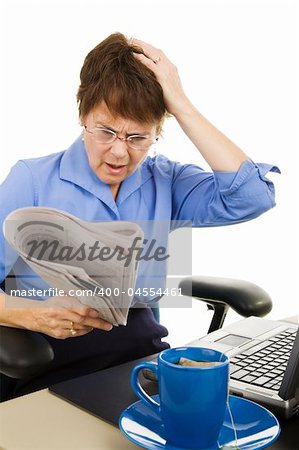 Business woman upset about what she's reading in the newspaper.  Isolated on white.