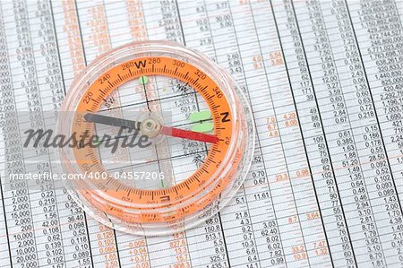 Close up of compass on stock market numbers