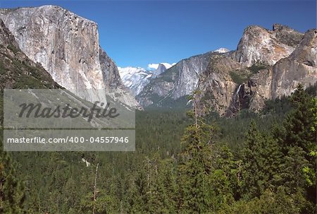 Tunnel View, within Yosemite National Park, is a viewpoint on State Route 41 located directly east of the Wawona Tunnel as one enters Yosemite Valley from the South. The view looks east into Yosemite Valley including the southwest face of El Capitan, Half Dome, and Bridalveil Falls. This is, to many, the first views of the popular attractions in Yosemite. Many cars stop right outside of the tunnel