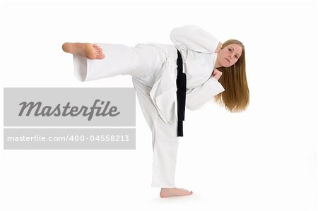 Black belt female martial artist doing side kick.