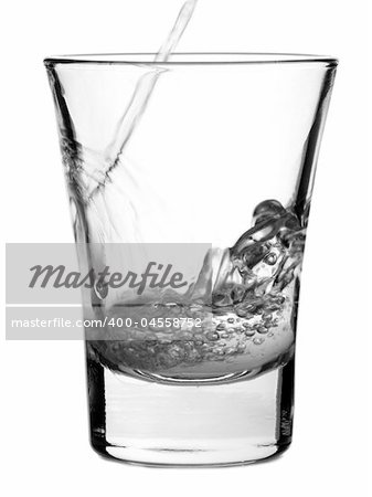 Pouring a shot of vodka on white background