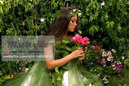 Mother Nature looking upon some of her many beautiful creations in her enchanted garden  This indoor studio shoot is a compilation of many fresh flowers, grass, tree branches and bushes.
