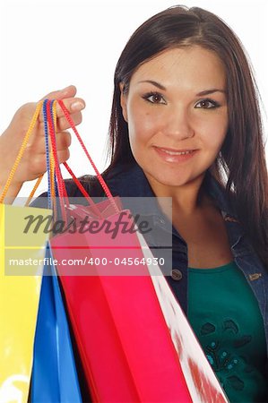 attractive brunette woman with shopping bags on white background