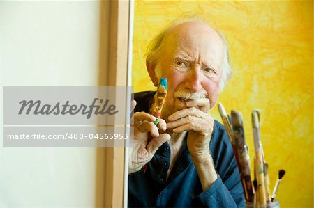 Elderly painter working on a large canvas