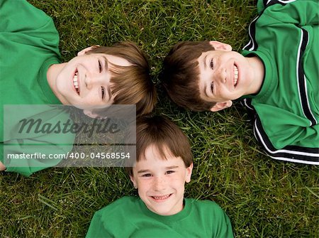 Three Brothers in Green Laying in the Grass