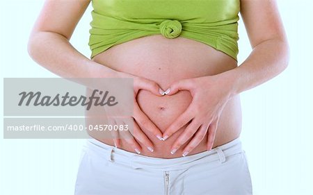 Pregnant woman showing her big tummy and making a Heart with the Hands