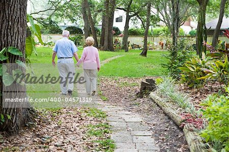 Senior couple strolling down a garden path together.  A metaphore for life's journey.