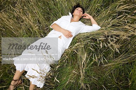 attractive brunette woman lying on meadow