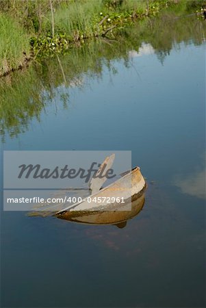 Old rusty barrel in a pond with still water