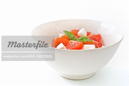 italian salad made with cherry tomatoes, Mozzarela chees, and fresh basil. Isolated on white