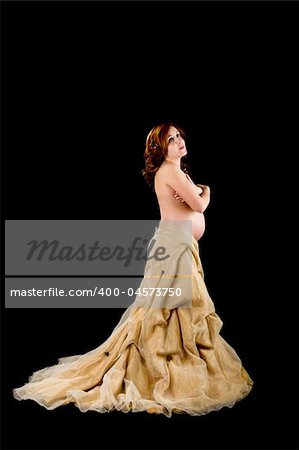 Pregnant woman posing on a black background with beautiful dress