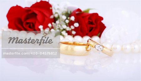 Still life with golden wedding rings and red roses