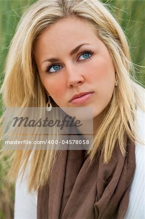 Portrait of beautiful young bond woman looking thoughtful, shot outside in natural daylight