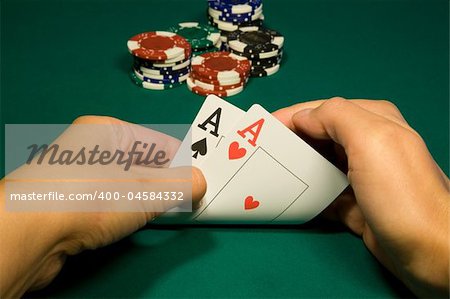 Two aces in hand in game poker on the green casino table