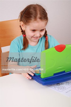 Cute little girl playing with computer