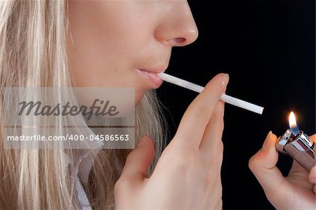 beautiful young girl with lighter smoking cigarette