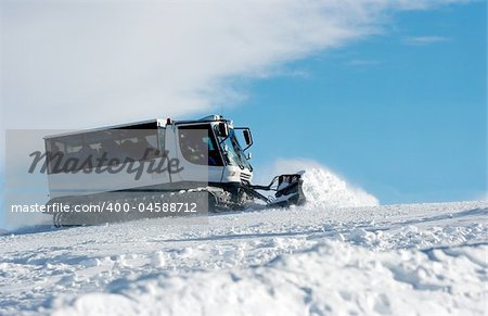 Ski slope with a white ratrak doing track maintenance