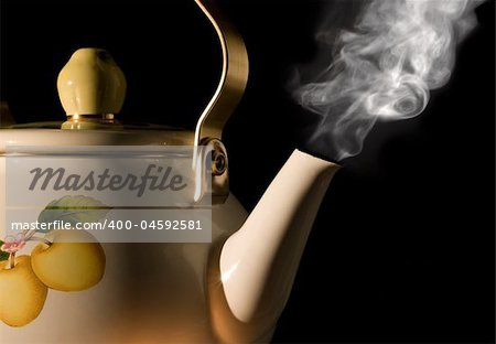 Tea kettle with boiling water on black background