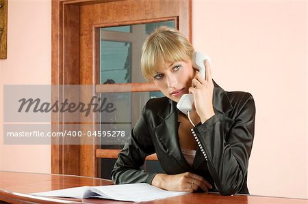 blond girl in Hotel reception talking at telephone