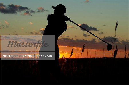 a silhouette of a golfer on a mourning sunset