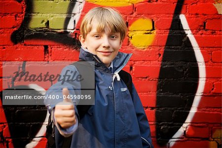 Cool kid standing in front of a graffiti wall