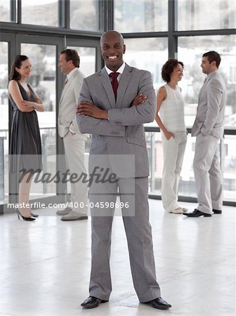 Potrait of a Business man standing smiling in front of team