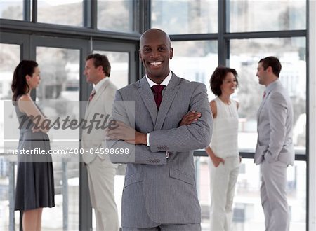 Potrait of a Business man standing smiling in front of team