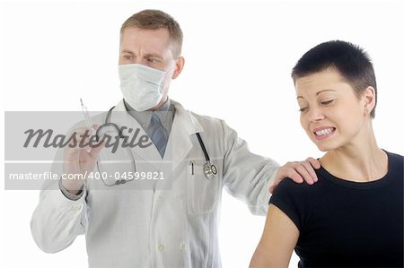 Doctor in gauze mask checks up a syringe while he holds a frightened woman by her shoulder
