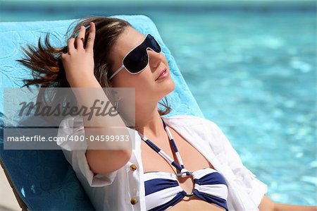 A young pretty Girl sunbathing by the pool