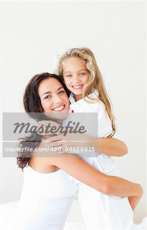 Young Mother and daugther embracing on bed