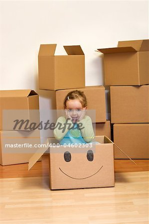Little girl in cardboard box with a smiley - moving concept