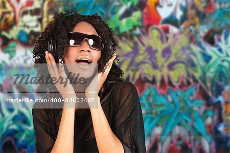 Black Woman Listening to Music on Headphones Against  Grunge Grafitti Background