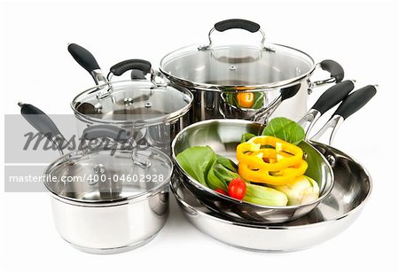Stainless steel pots and pans isolated on white background with vegetables