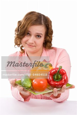 Woman wants to eat fresh vegetables. Housewife is holding the plate with pepper, tomato, cucumber. Pretty girl with fresh vegetables. Isolated over white background.