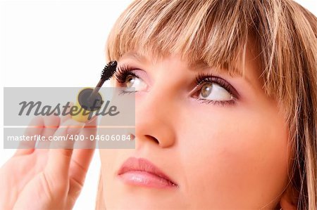 Young woman make up her eyelash isolated on white