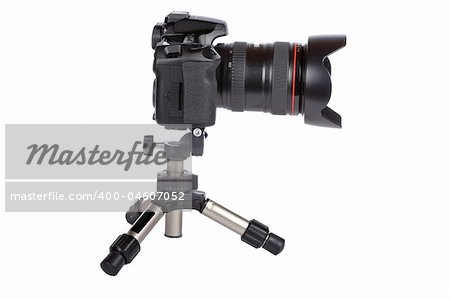 Digital slr camera and mini tripod isolated on white background