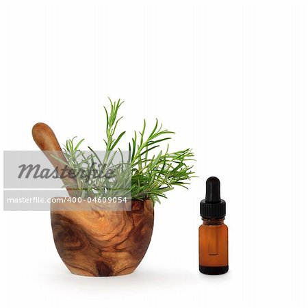 Rosemary herb leaves in an olive wood mortar with pestle and aromatherapy essential oil glass dropper bottle, over white background.