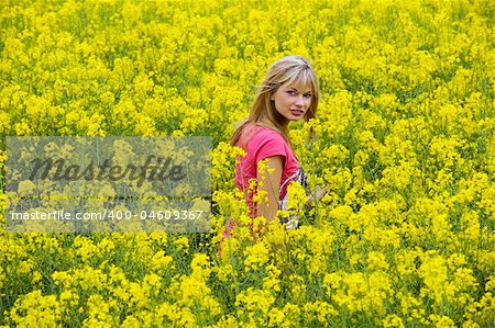 Happy blond girl with pink t-shirt in a yellow field